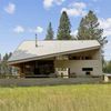 Backed by majestic mountains and trees, a strikingly designed Vrbo with angular roof in Montana