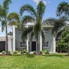 Palm trees in front of a grand Vrbo with tall pillars in Cocoa Beach, Florida