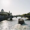A boat plies the waters of the Seine on a sunny day in Paris