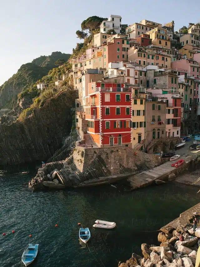 The colorful hillside buildings of Cinque Terre, Italy, with boats in the harbor below
