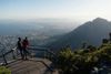 Two people stand on a viewing platform on Table Mountain, overlooking the city and bay of Cape Town, South Africa
