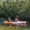 Two people paddle a kayak through scenic mangroves in Florida