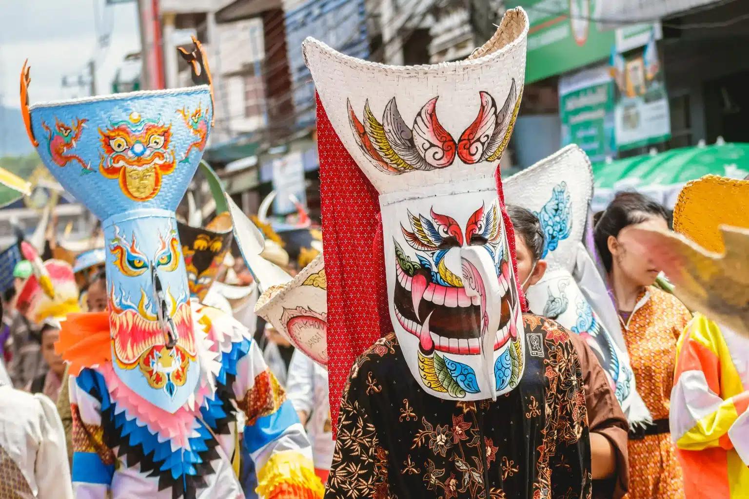 People wear colorful masks as part of the Phi Ta Khon ghost festival parade in Thailand
