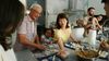 A three-generation, multi-racial family prepares dumplings together on a large kitchen island