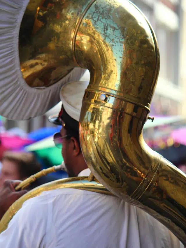 A musician wearing a peaked hat plays a sousaphone, a brass instrument in the tuba family, in New Orleans