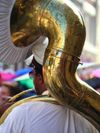 A musician wearing a peaked hat plays a sousaphone, a brass instrument in the tuba family, in New Orleans