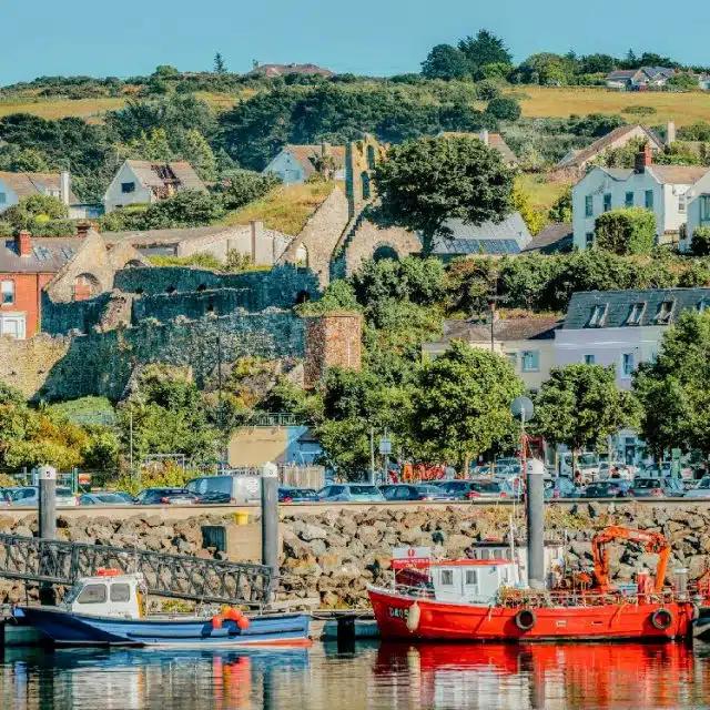 Fishing boats line the harbour with homes built up on the hillside in the picturesque village of Howth, County Dublin, Ireland