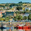 Fishing boats line the harbour with homes built up on the hillside in the picturesque village of Howth, County Dublin, Ireland