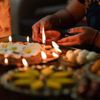 A person lights traditional Diya lamps