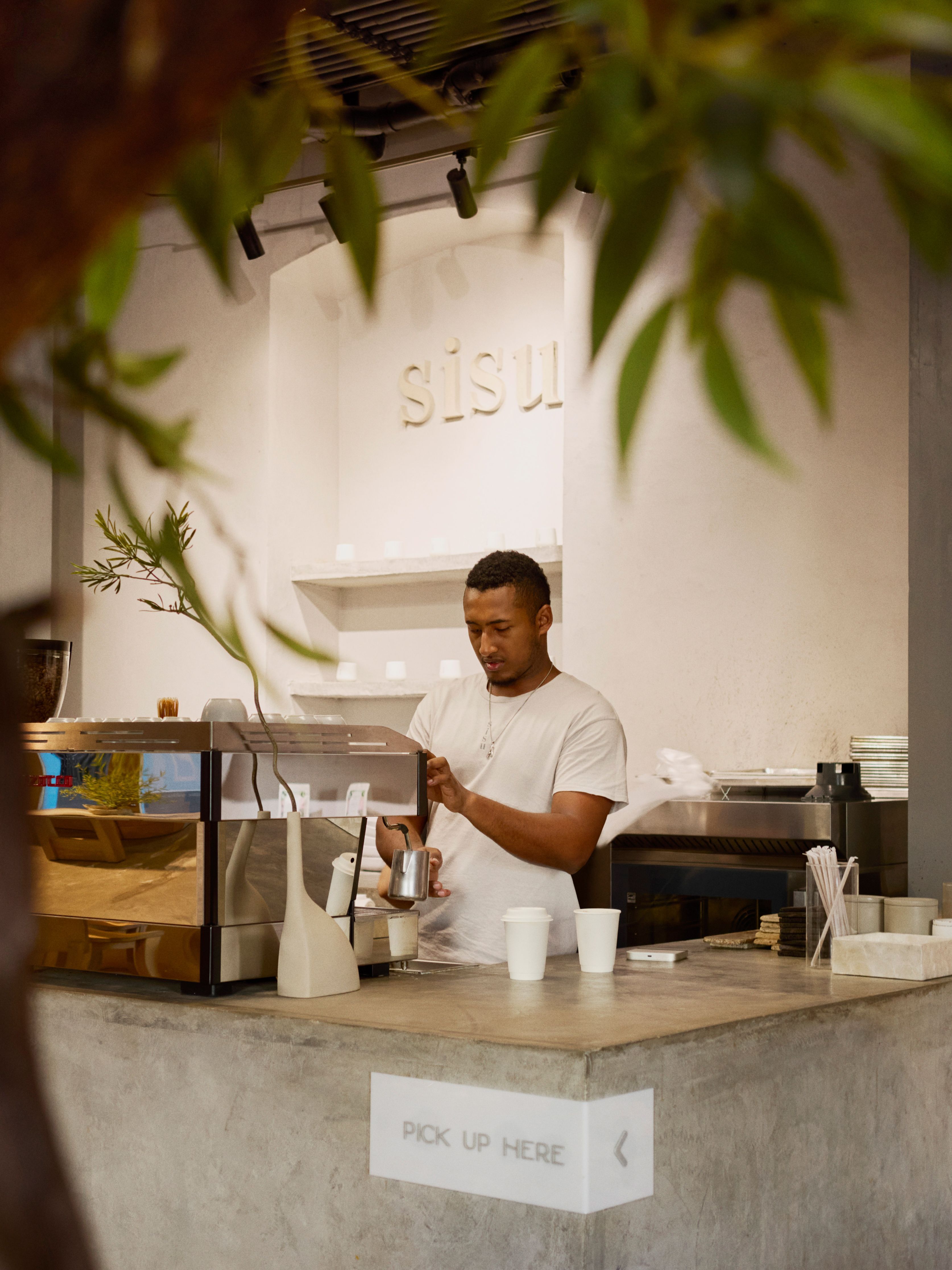 A barista steams milk behind the counter at Sisu Coffee Studio in Casco Antiguo, Panama