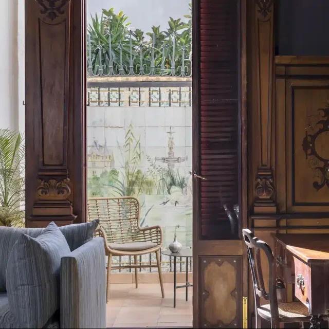 The ornate carved wooden walls, decorative antiques, and pretty courtyard terrace at Palma’s historic Hotel Can Cera