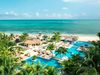 Pools, cabanas, and palm trees surround a pool at an all-inclusive resort in Jamaica.