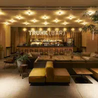 The gold-colored decor and bright lights of the bar at the Trunk (Hotel) Cat Street