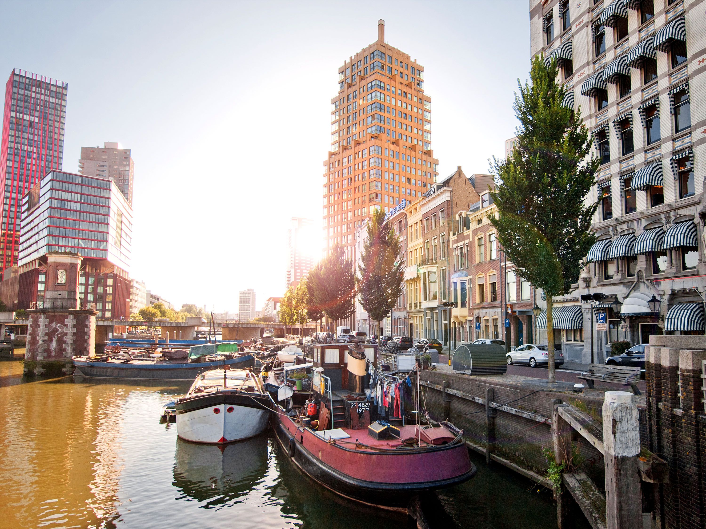 Canal with boats in front of modern buildings.