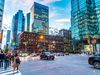 People cross a busy street in downtown Toronto.
