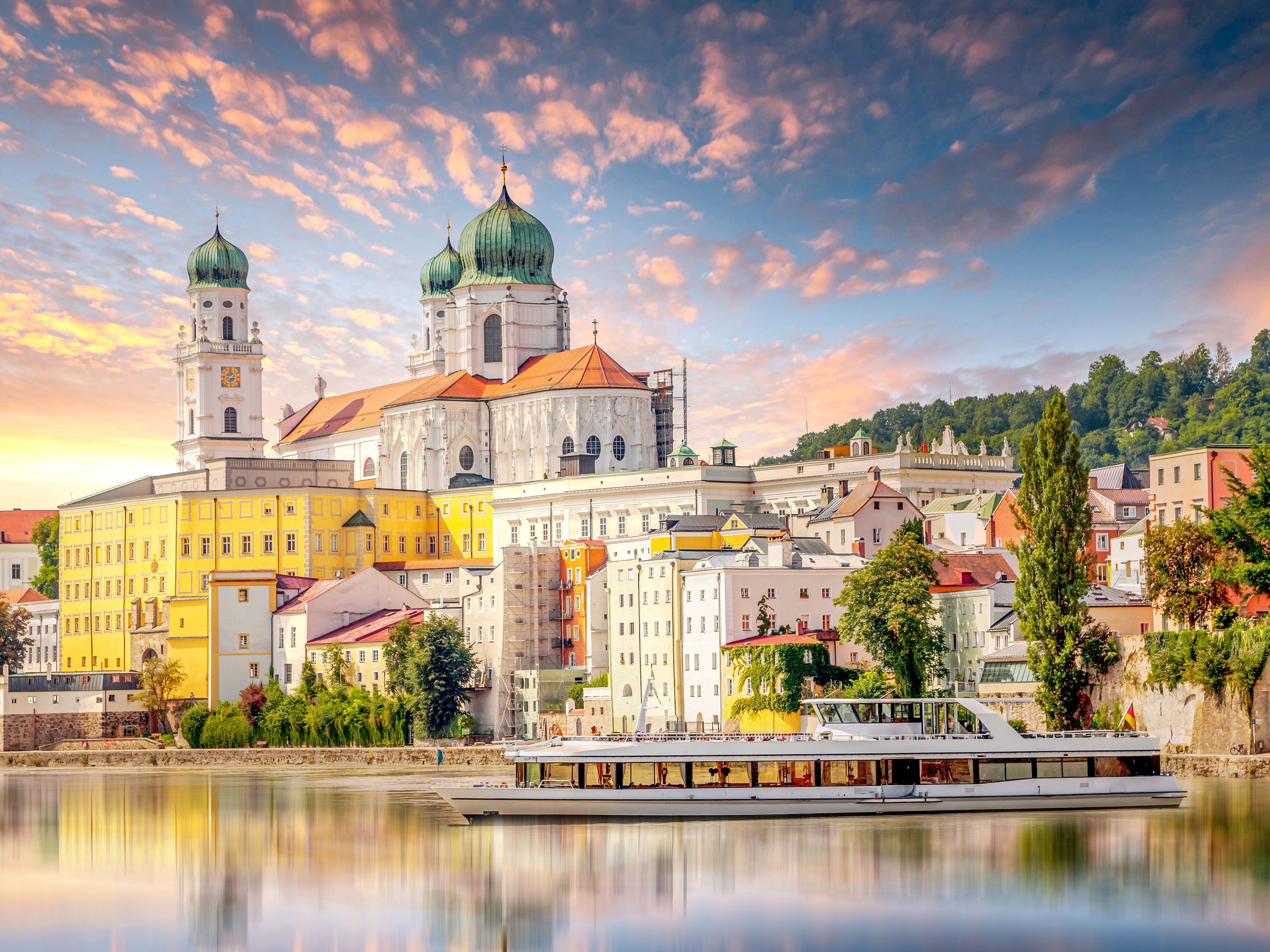 Aerial view of Regensburg at warm glowing sunset with the Stone Bridge over the Danube River and the twin towers of St. Peter’s Cathedral