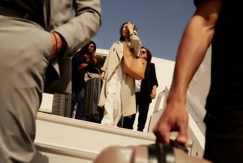 View of people departing an airplane carrying had luggage