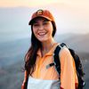 Travel influencer Renee Hanel, aka Renee Roaming, wears an orange cap and windproof jacket and smiles for a photo in Joshua Tree, California