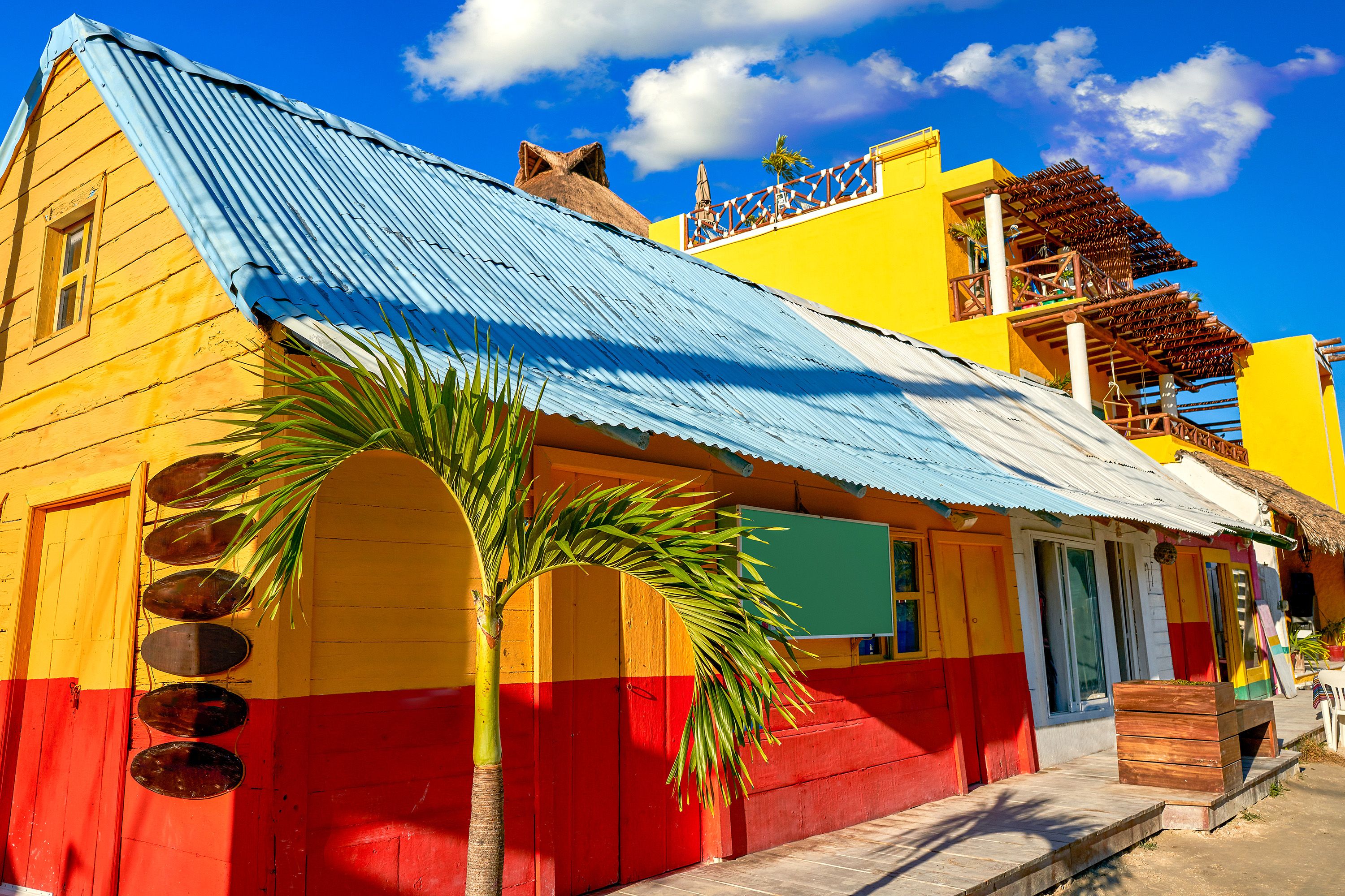 Colorful building with palm trees and blue skies.