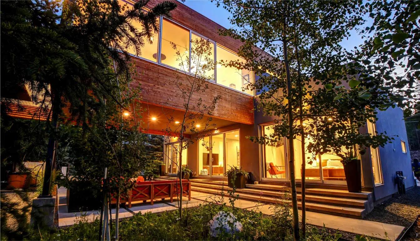 A mid-century chalet illuminated by lights in Winter Park, Colorado 