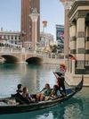 A family rides in a gondola on the water surrounding The Venetian hotel in Las Vegas, Nevada