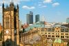 A Gothic clock tower and historic buildings with a modern city skyline in the background.