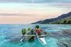 A man on a canoe in the ocean of Mo'orea, Polynesia.