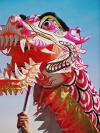 A hand holds aloft a Chinese dragon head during a Lunar New Year parade in Chicago, IL