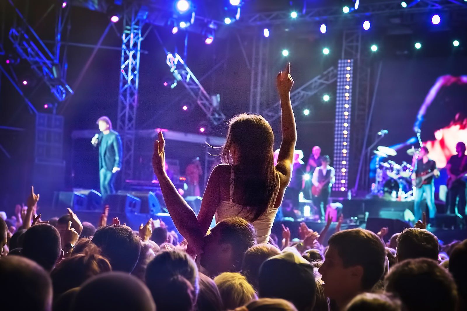A crowd watches a live band at a music festival