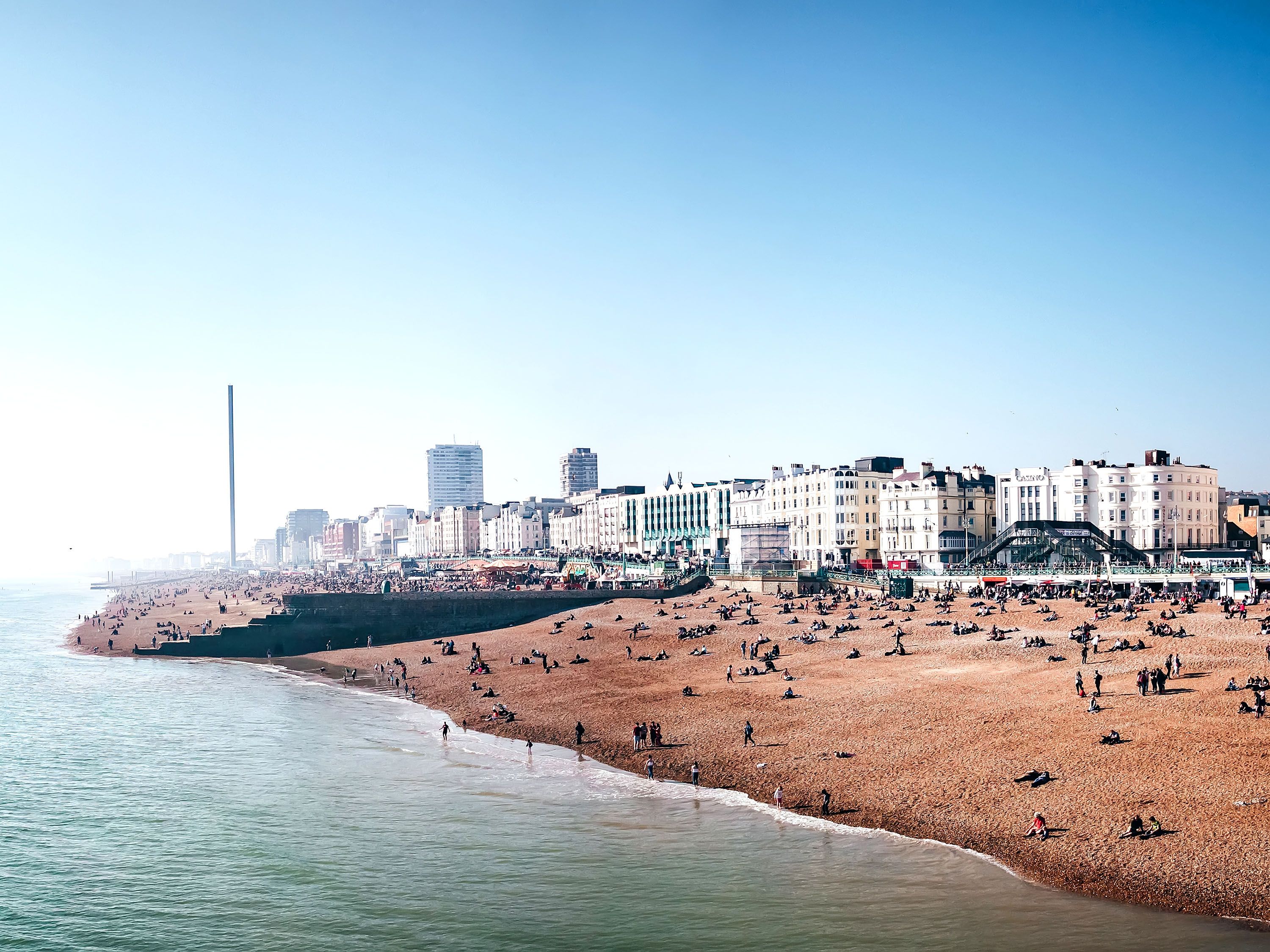 Cloudy beach with buidlings and boardwalk area.