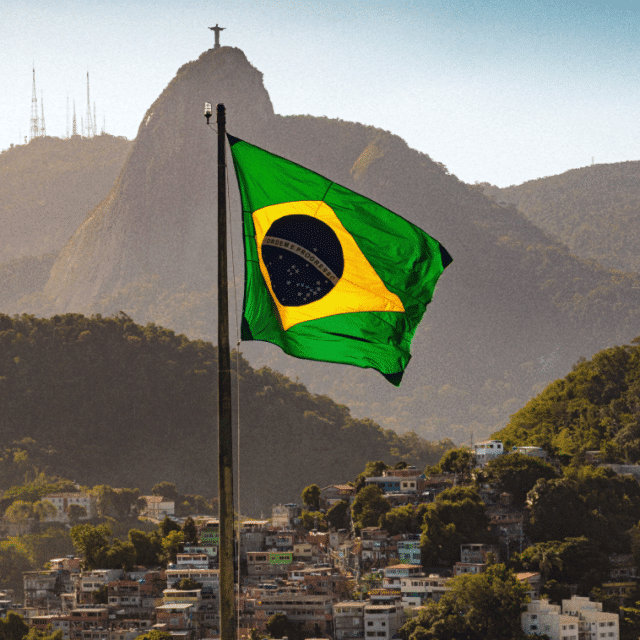 The Brazilian flag blowing in the wind over a view of Rio de Janeiro, Brazil