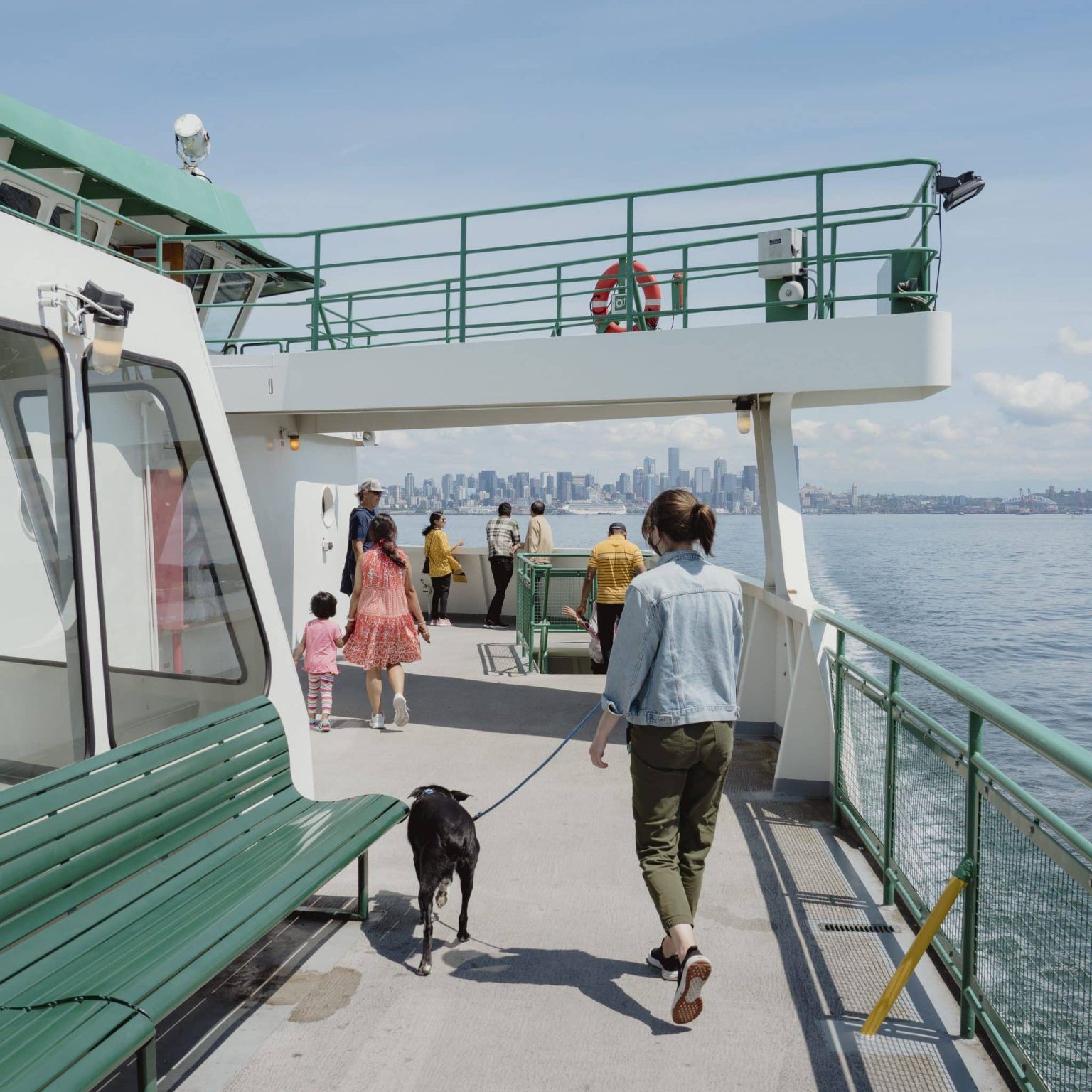 A woman walks a dog on a lead on the Washington State Ferry, off Seattle 