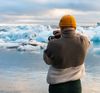 Photographer capturing melting glacier pieces in Iceland