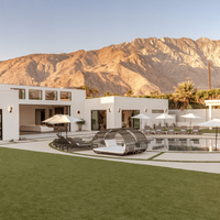 The garden of the mid-century-modern "Spahaus" Vrbo vacation rental in Palm Springs, California, mountains seen behind in the distance