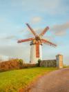 A white windmill with red sails in Skerries, Ireland
