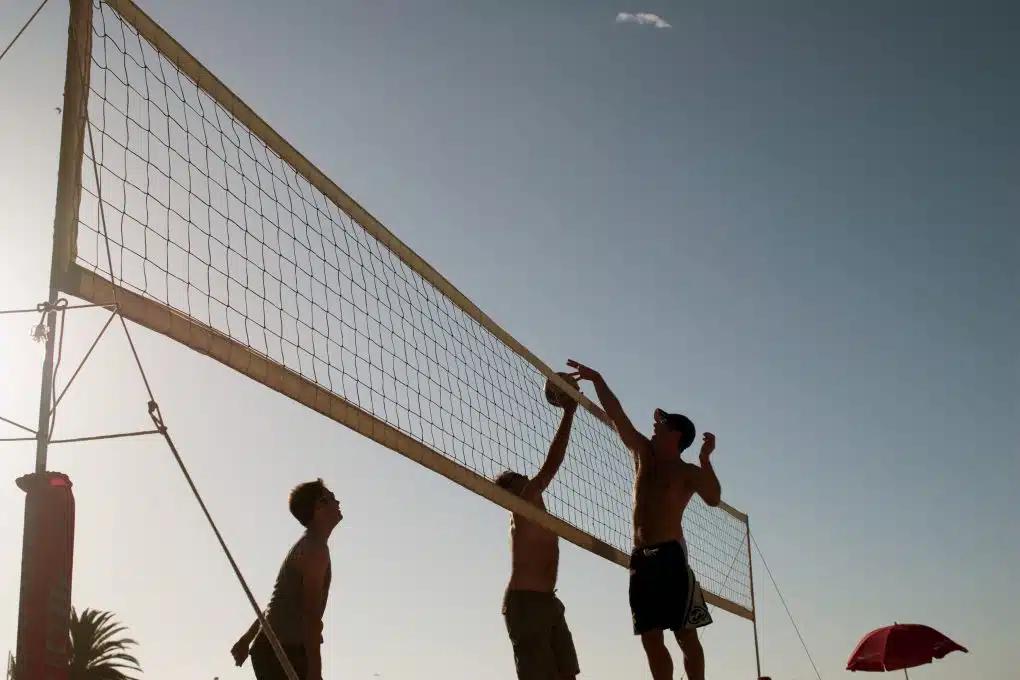 People play beach volleyball on a sunny day