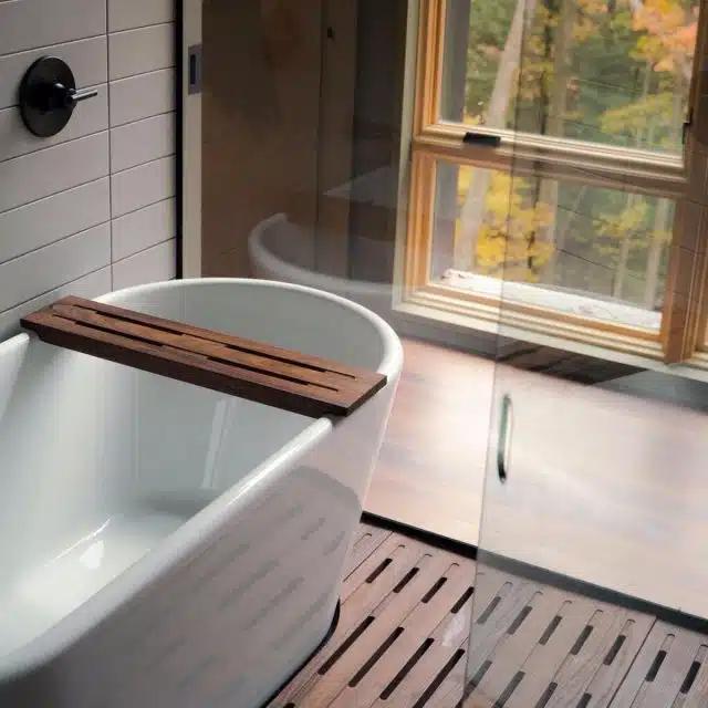 A modern bath tub with views of the woods
