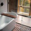 A modern bath tub with views of the woods