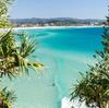 A surfer paddles over a wave in the turquoise waters of Greenmount Beach on Queensland's Gold Coast in A