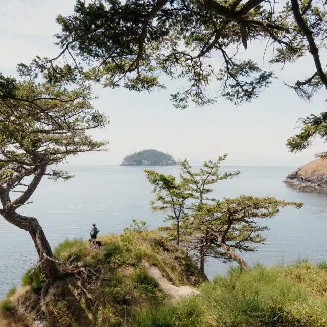 A person hikes along the coastline of Puget Sound in Seattle, Washington State