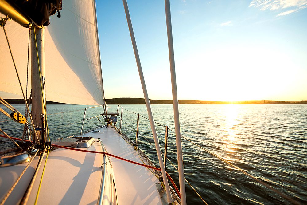 A sail boat at sunset.