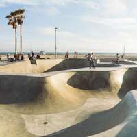 Skaters navigate the smooth curves of a skate park, Venice Beach