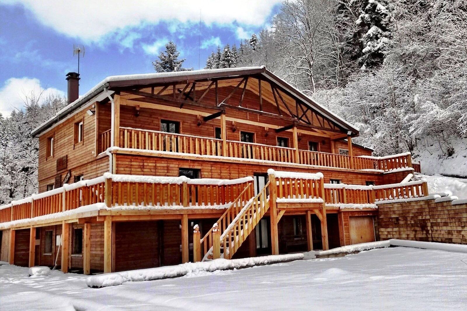 Grand chalet en bois sous la neige dans une vallée, à La Bresse dans les Vosges, disponible sur Abritel