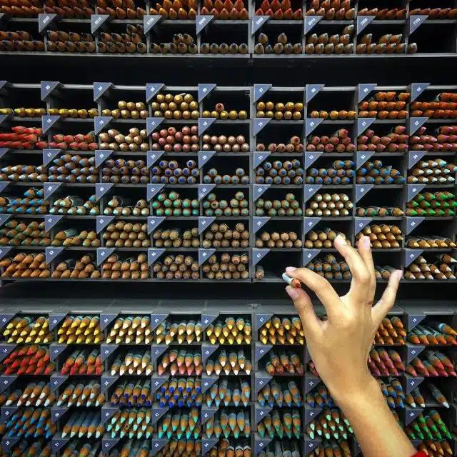 A hand selects a colored pencil from a wide array of different options at Itoya stationery store in Tokyo, Japan