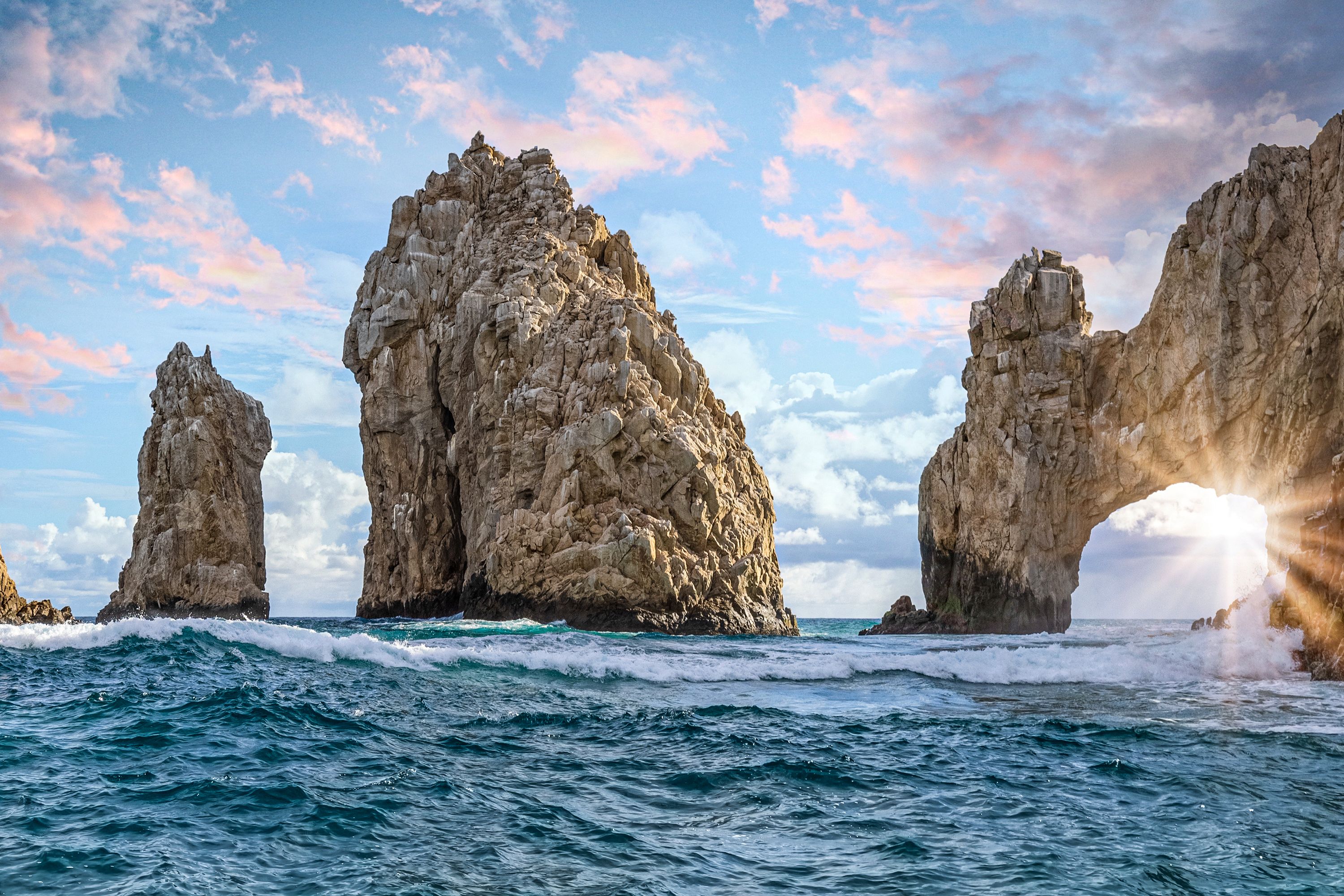 Stone formations in choppy water including a stone arch.