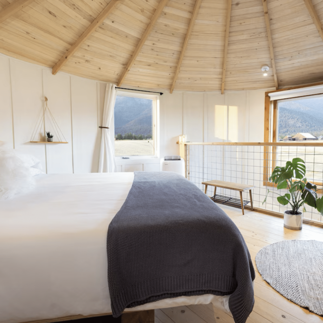 Interior view of a converted grain silo in Montana, furnished with a bed, rug and plants