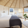 Interior view of a converted grain silo in Montana, furnished with a bed, rug and plants