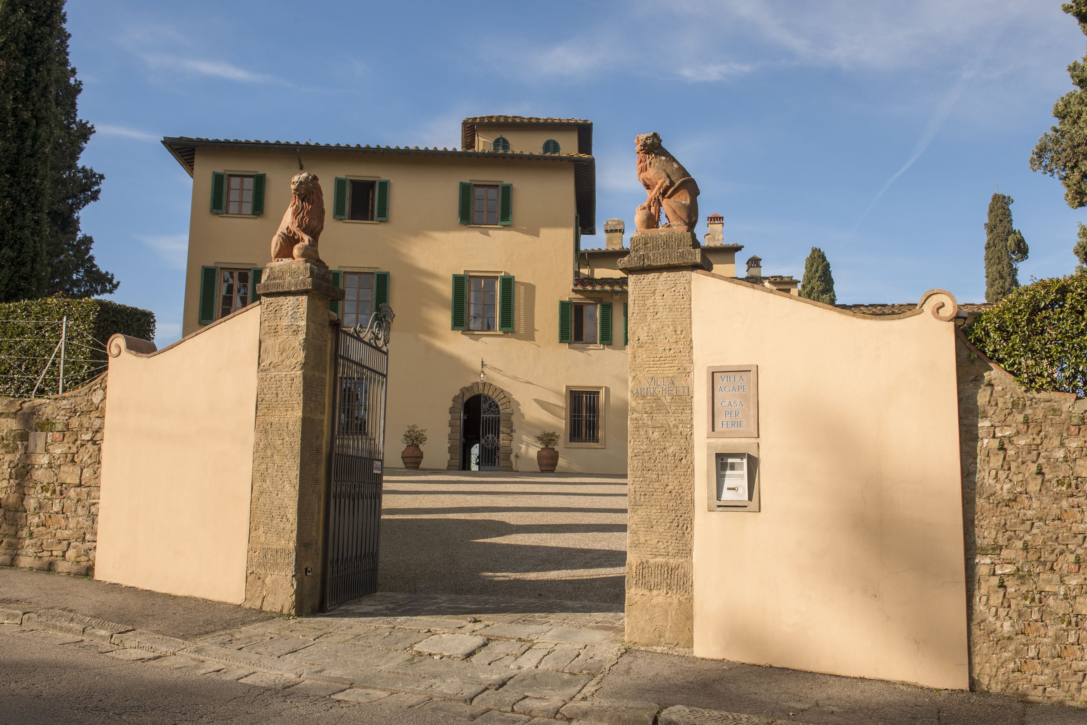 An exterior gate leading to the entrance of Art Hotel Villa Agape in Florence