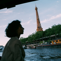 A silhouetted woman on a boat on the Seine, the Eiffel Tower visible behind her