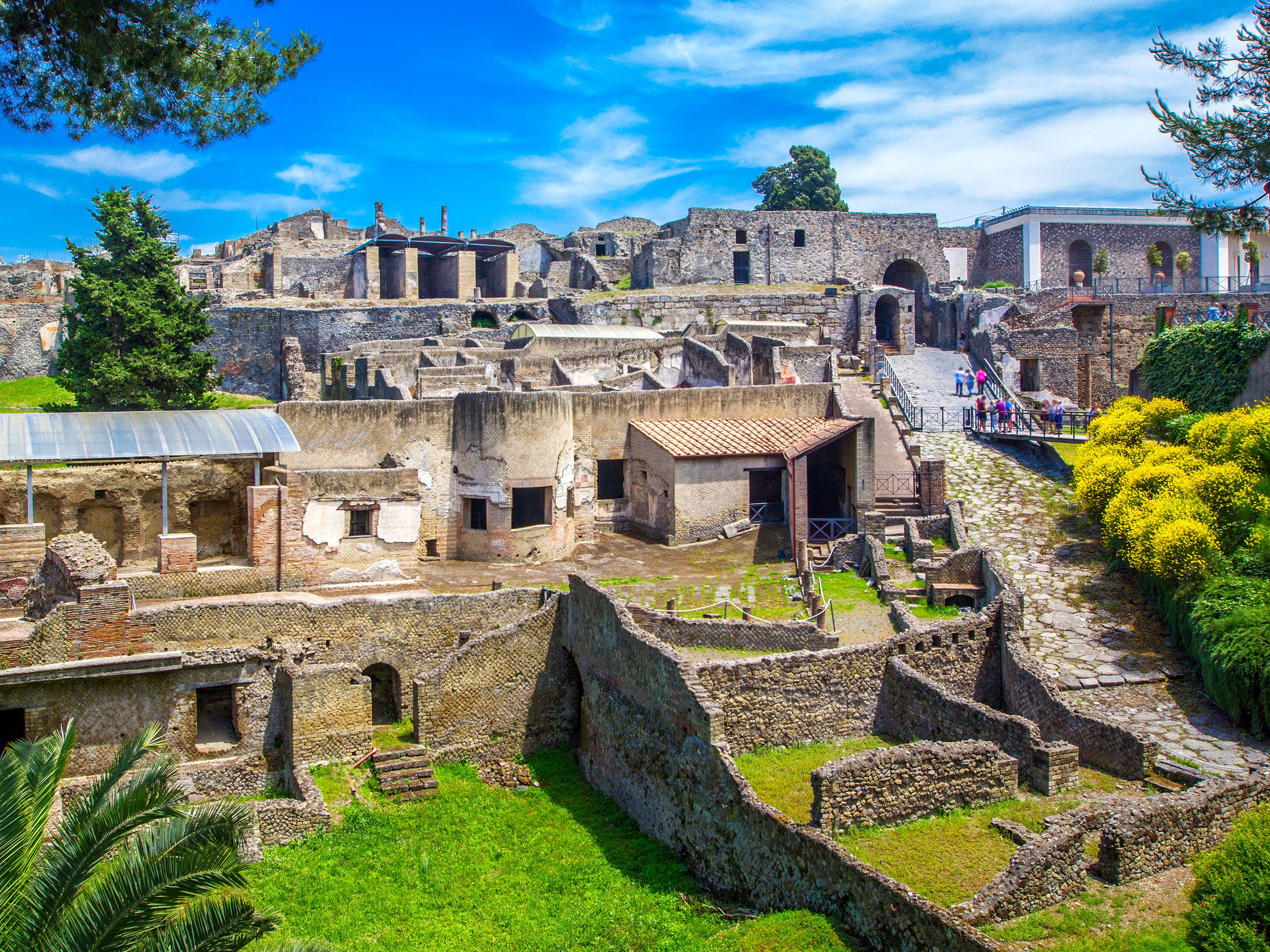 Ancient ruins with green grass and blue sky.